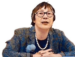 A mirror reversed enhanced colorized photographic cutout of a glasses wearing Emanuela Scribano with a mottled blue and green jacket with a rounded neck black collarless shirt under white pearls.