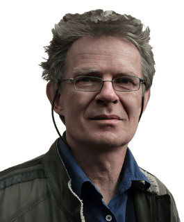 A reversed enhanced color photographic headshot cutout of a glasses adorned Galen Strawson wearing a dark  blue shirt under a green outerwear coat used for visually identifying him.