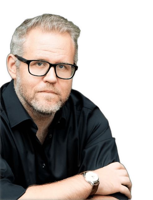 An enhanced photographic headshot cutout of a glasses wearing Frans Svensson with his arms crossed and a watch on his right wrist while wearing a black colored shirt used to visually identify him.