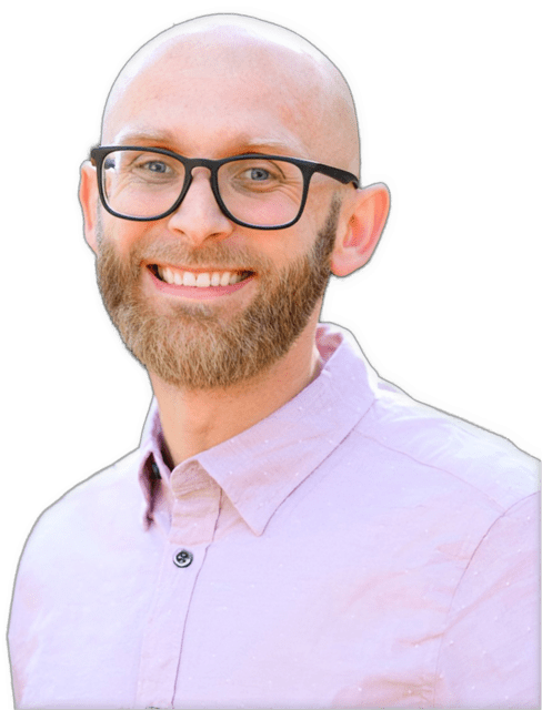 An enhanced photographic headshot cutout of a smiling Manuel Fasko with dark framed glasses and a full beard wearing a light purple collared shirt with one button showing with his head turned slightly to his left used to visually identify him.