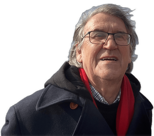 A reversed enhanced color photographic headshot cutout of Ruedi Imbach with glasses outdoors wearing a red scarf under a black heavy wool overcoat used to visually identify him.