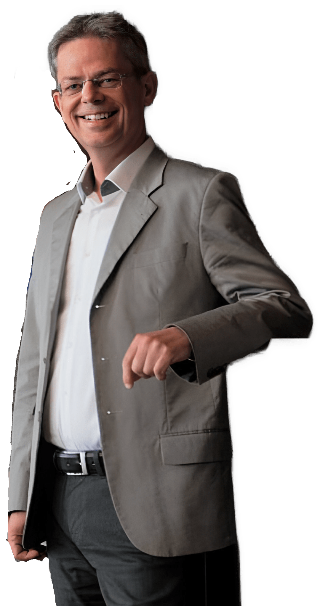 An enhanced color photographic upper thigh to headshot cutout of a smiling Dominik Perlerr with rimless glasses with his head bent down looking to his left with his left arm on a support (unseen) and wearing a white open collared shirt with no tie under a gray  suit coat and darker gray pants used to visually identify him.