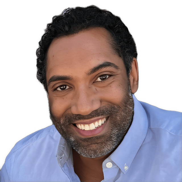 This is a reversed enhanced color photographic cutout headshot of a smiling, full-bearded Elliot Samuel Paul without glasses facing forward, wearing a blue collared shirt with white buttons used to visually identify him.